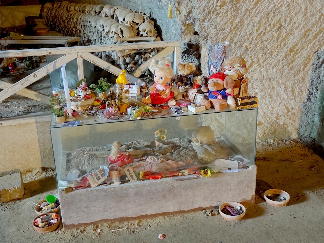 crânes et offrandes dans le cimetière des Fontanelle de Naples